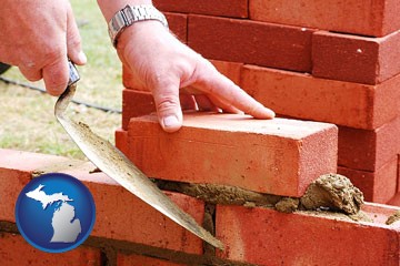 a bricklayer laying brick, building a brick wall - with Michigan icon