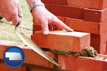 a bricklayer laying brick, building a brick wall - with Nebraska icon