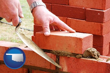 a bricklayer laying brick, building a brick wall - with Oklahoma icon